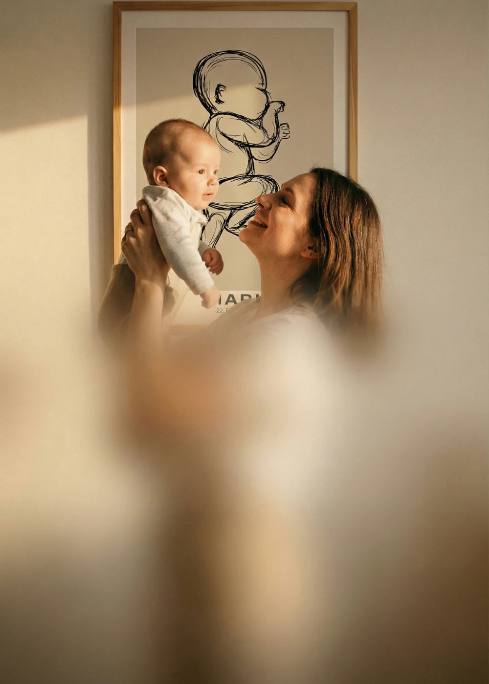 Personalisiertes 1:1 Geburtsposter im Kinderzimmer: Mutter zeigt ihrem Baby die Zeichnung in echter Originalgröße der Geburt.